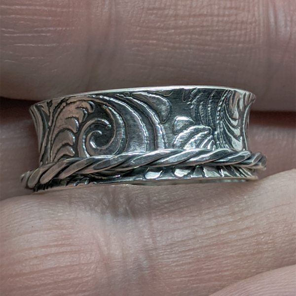 Tooled leather pattern flared ring with spinning twisted sterling band